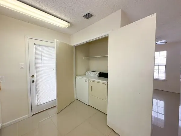 a utility room with cabinets washer and dryer
