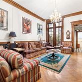 a living room with furniture large window and a chandelier