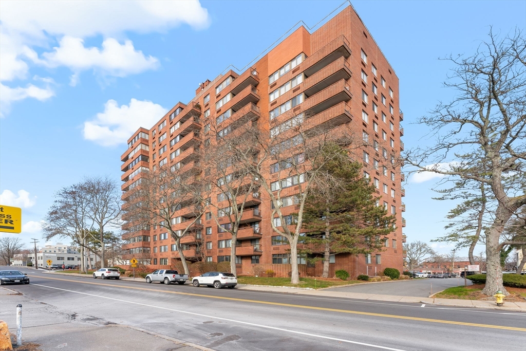 a view of a tall building next to a road