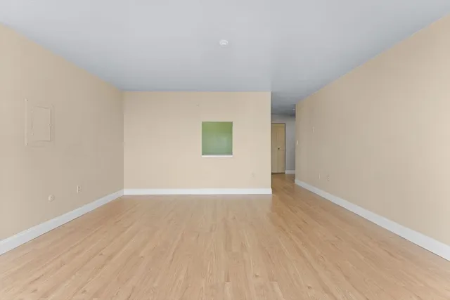 a view of an empty room with wooden floor