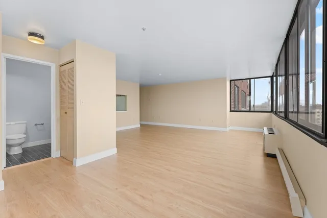 a view of a hallway with bathroom and wooden floor