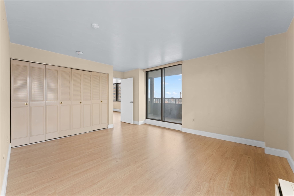 77 Adams Street, Unit 610 Quincy, MA 02169 - Photo 14 of 32 a view of an empty room with wooden floor and a window