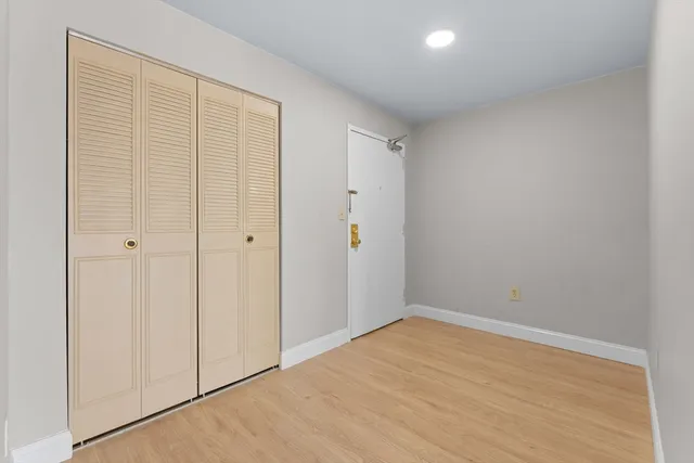 a view of empty room with wooden floor