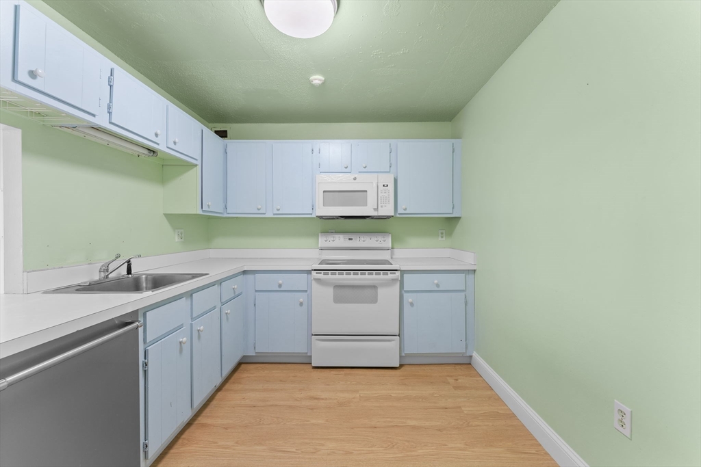 77 Adams Street, Unit 610 Quincy, MA 02169 - Photo 17 of 32 a kitchen with a sink cabinets and stainless steel appliances