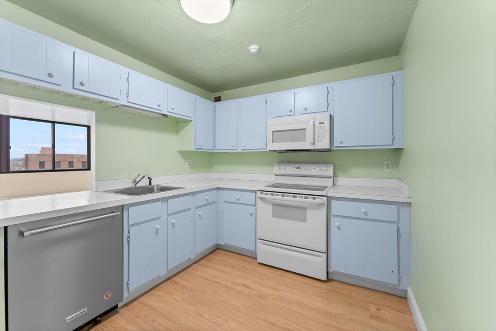 77 Adams Street, Unit 610 Quincy, MA 02169 - Photo 18 of 32 a kitchen with cabinets appliances a sink and a window