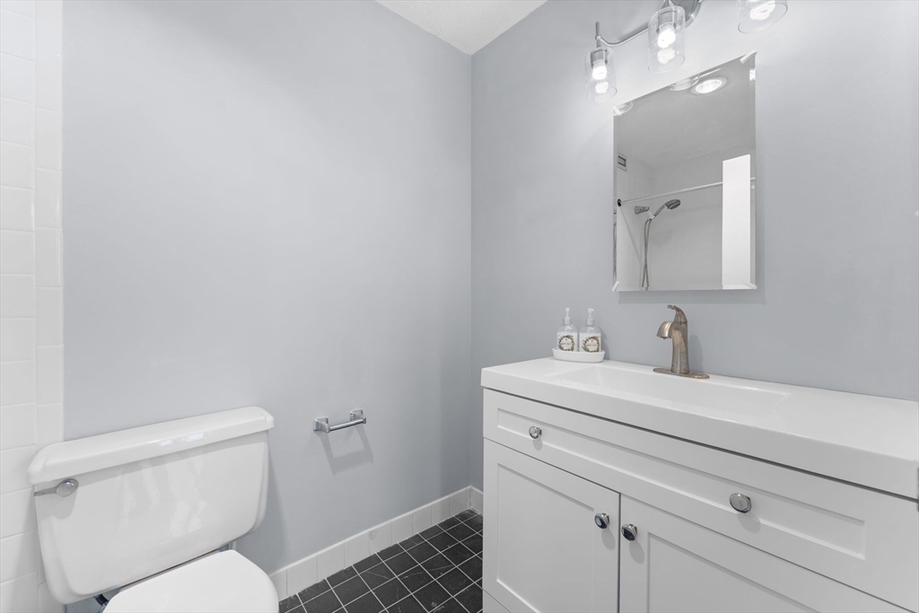 77 Adams Street, Unit 610 Quincy, MA 02169 - Photo 21 of 32 a bathroom with a toilet sink and mirror