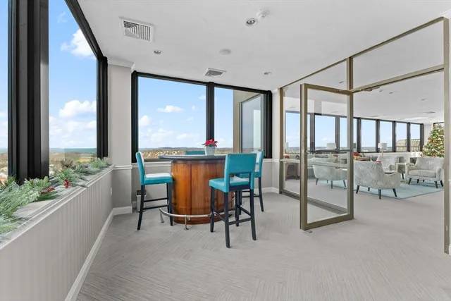 a dining room with furniture and a floor to ceiling window