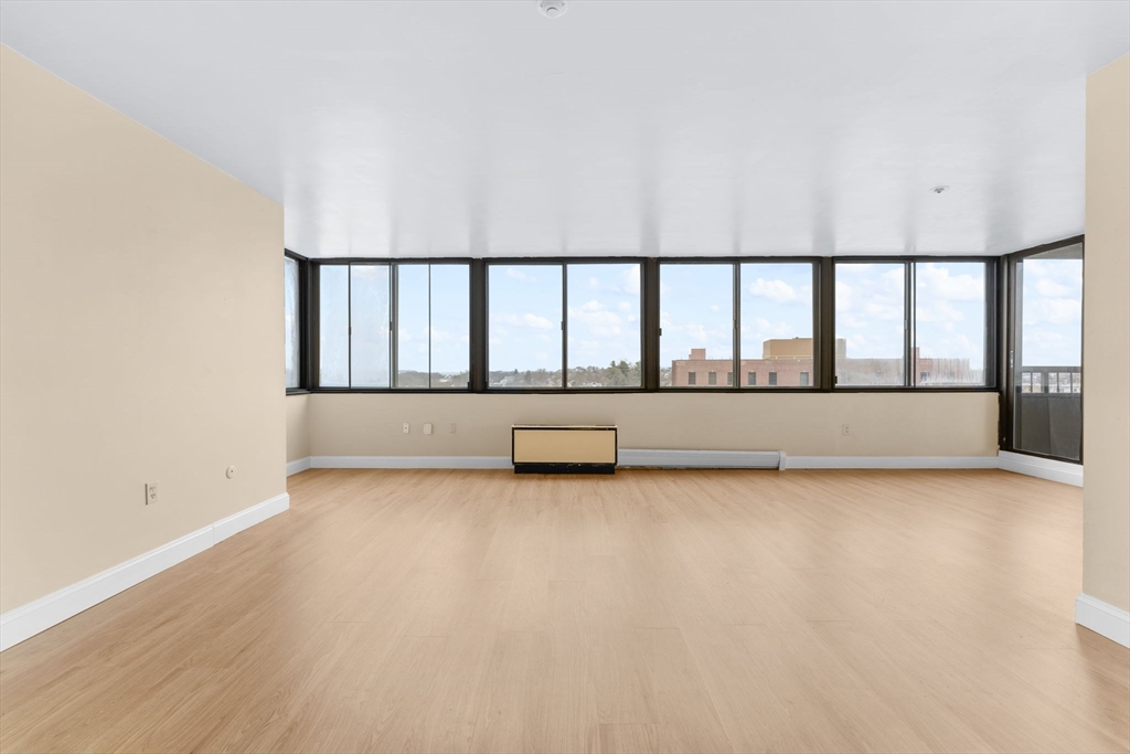 77 Adams Street, Unit 610 Quincy, MA 02169 - Photo 9 of 32 a view of a large room with wooden floor and a balcony