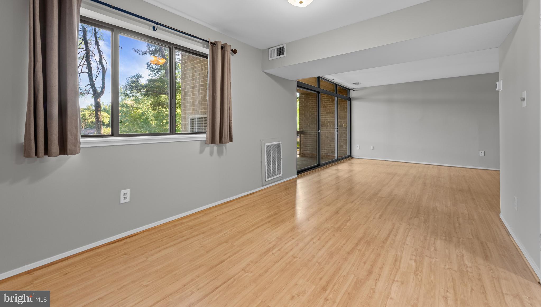 1645 Parkcrest Circle, Unit 200 Reston, VA 20190 - Photo 21 of 29 a view of an empty room with wooden floor and a window