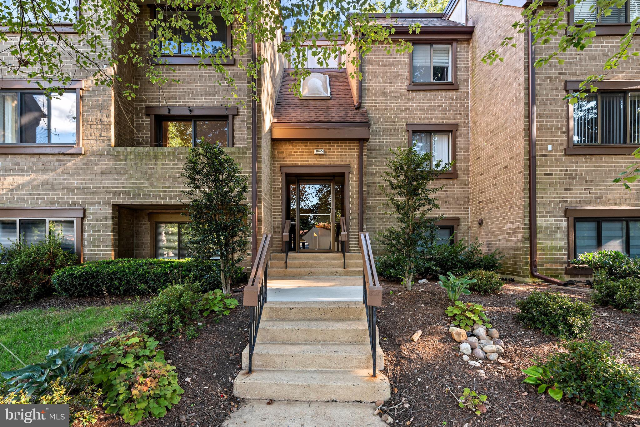 1645 Parkcrest Circle, Unit 200 Reston, VA 20190 - Photo 24 of 29 a front view of a house with plants and garden