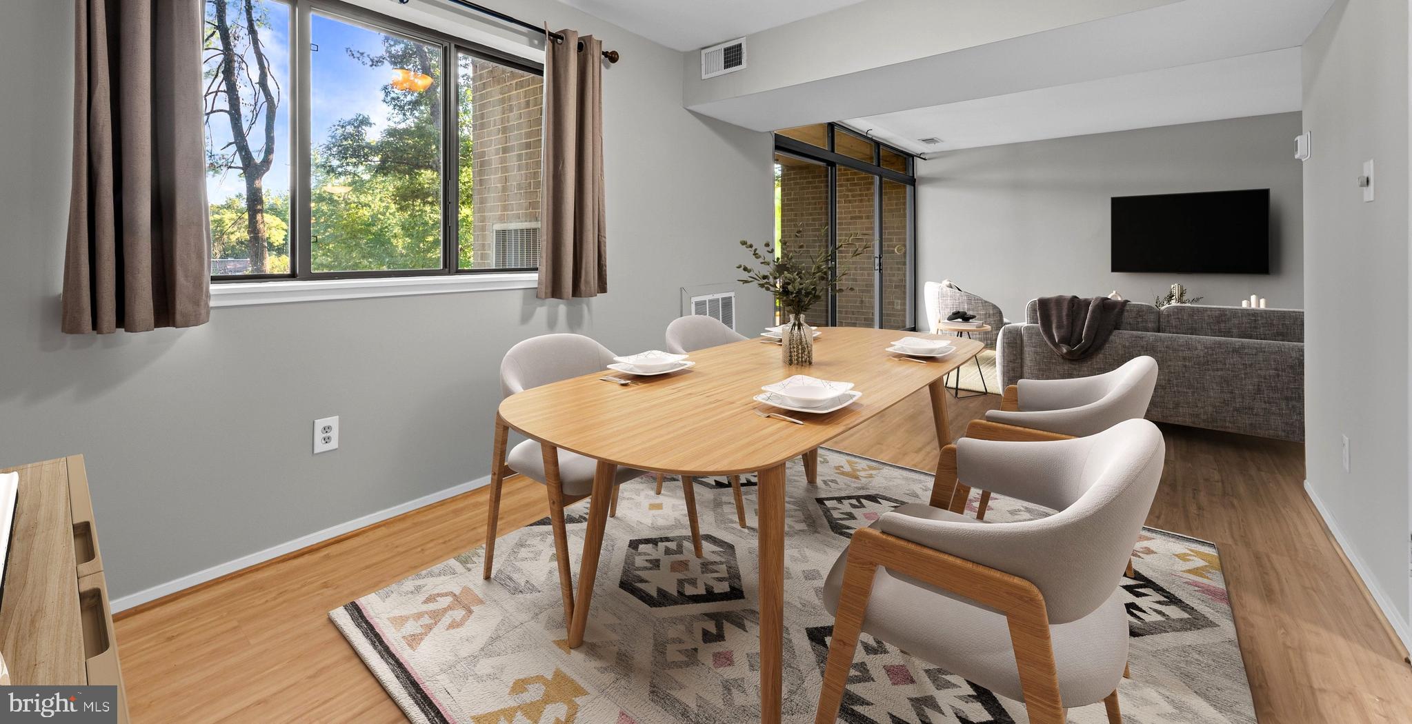 1645 Parkcrest Circle, Unit 200 Reston, VA 20190 - Photo 4 of 29 a dining room with furniture a window and a flat screen tv