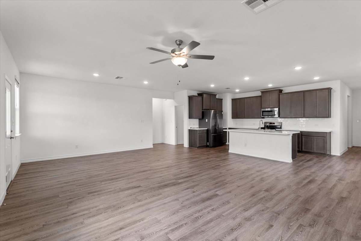 500 Stinchcomb Road Hutto, TX 78634 - Photo 12 of 37 An open-concept living area flows into a kitchen with an island and recessed lighting.