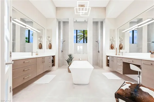 a spacious bathroom with a double vanity sink a mirror a bathtub and