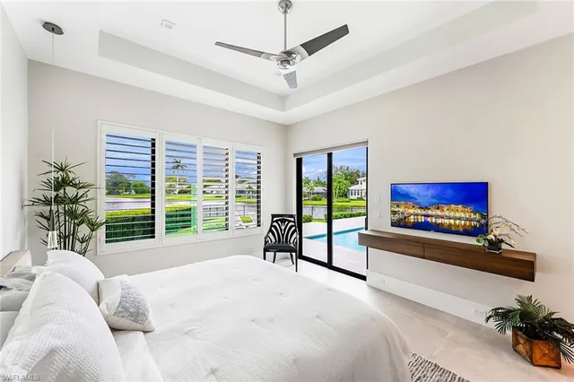 a bed sitting in a spacious bedroom next to a window