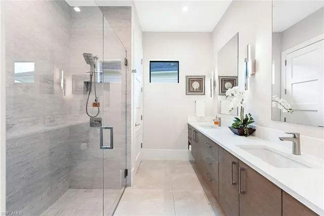 a bathroom with a double vanity sink mirror and shower