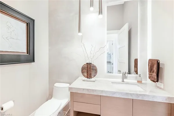 a bathroom with a sink a toilet and mirror