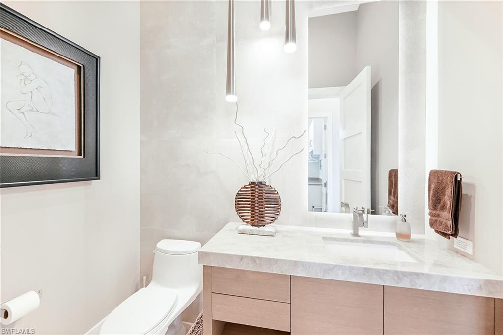 4646 Crayton Road Naples, FL 34103 - Photo 19 of 26 a bathroom with a sink a toilet and mirror