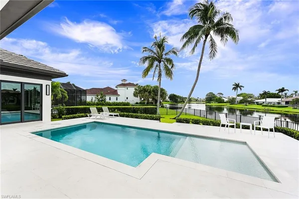 a view of swimming pool with outdoor seating and a garden