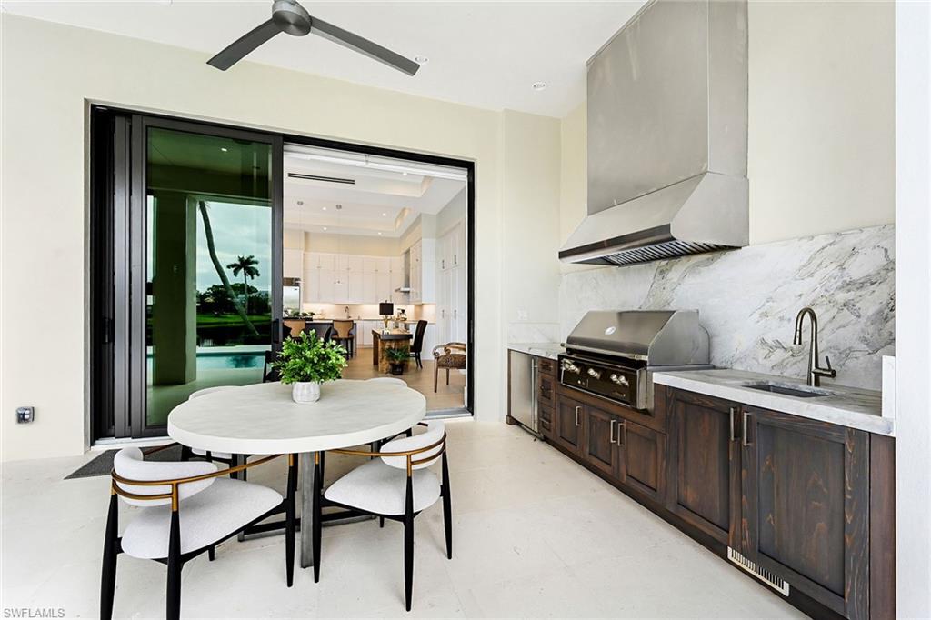 4646 Crayton Road Naples, FL 34103 - Photo 23 of 26 a kitchen with a table chairs stove and cabinets