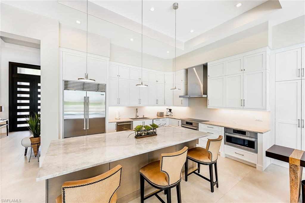 4646 Crayton Road Naples, FL 34103 - Photo 6 of 26 a kitchen with a table chairs stove and cabinets