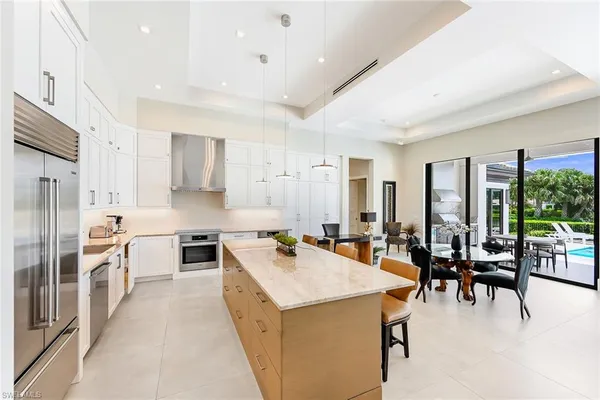 a large kitchen with stainless steel appliances lots of counter space and furniture