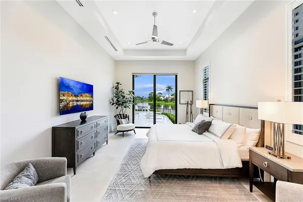 a spacious bedroom with a large bed and a flat screen tv