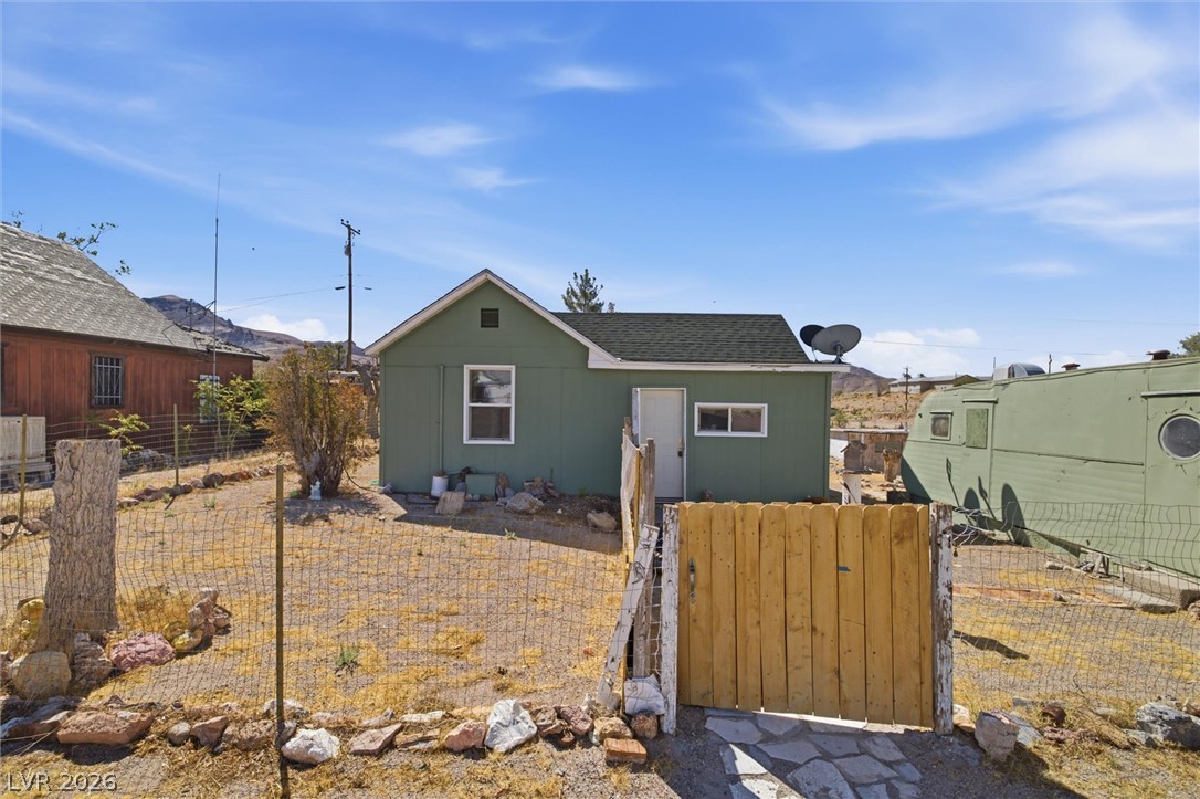 405 Main Street Beatty, NV 89003 - Photo 2 of 28 A quaint green cottage with a fenced yard offers a serene desert escape.