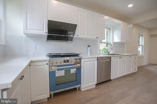 a kitchen with white cabinets and white appliances