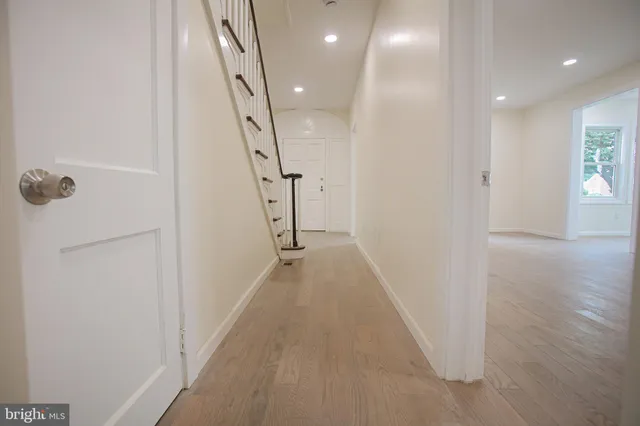a view of a hallway with wooden floor and staircase