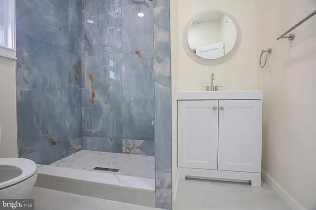 a bathroom with a sink a toilet and a mirror