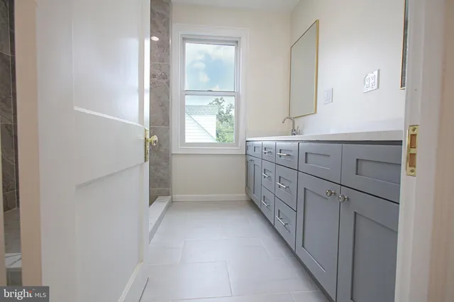 a bathroom with a double vanity sink a window and a mirror