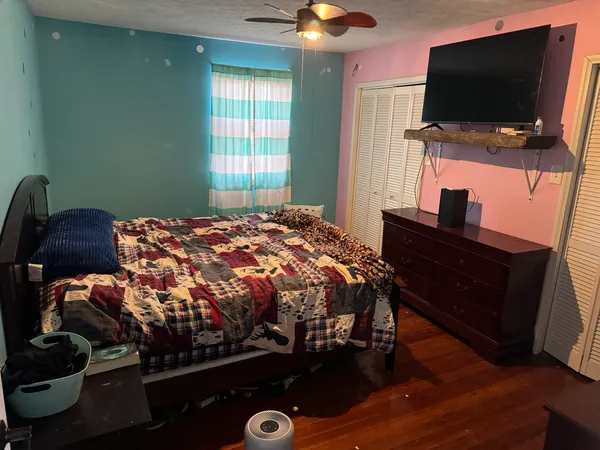 a bedroom with a bed and a flat screen tv