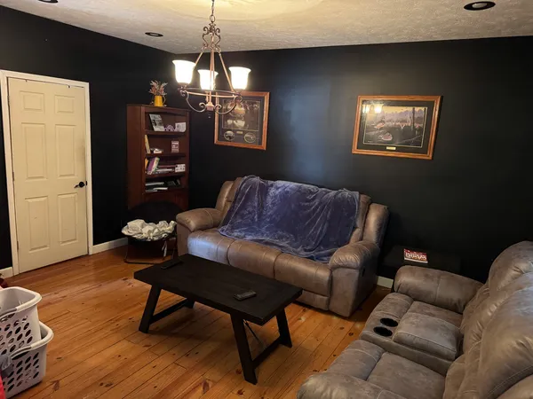 a living room with furniture a chandelier and a window