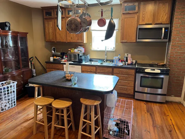 a kitchen with granite countertop a table chairs stove and microwave