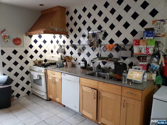 a kitchen with white cabinets and black appliances