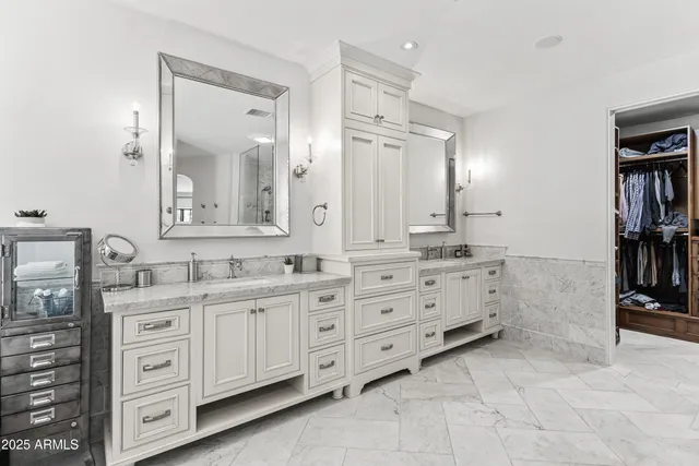 a bathroom with a granite countertop double vanity sink a mirror and a bathtub