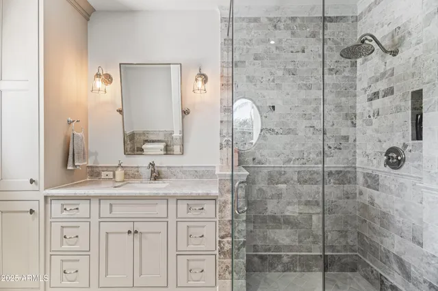 a bathroom with a granite countertop shower sink and mirror
