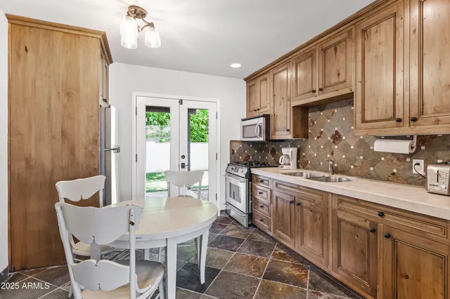 a kitchen with stainless steel appliances granite countertop a kitchen island hardwood floor a sink and a window