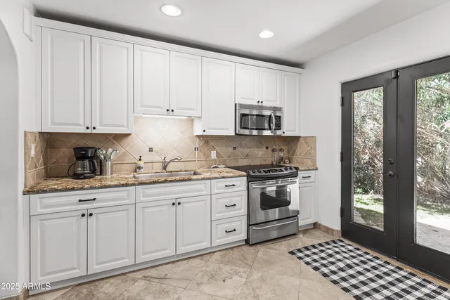 a kitchen with stainless steel appliances granite countertop a stove a sink and a refrigerator