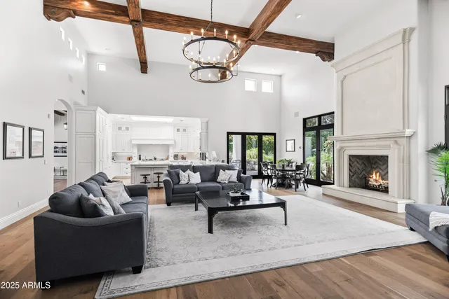 a living room with furniture kitchen view and a large window