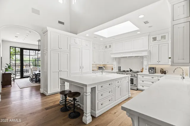 a kitchen that has a lot of cabinets a sink and wooden floor