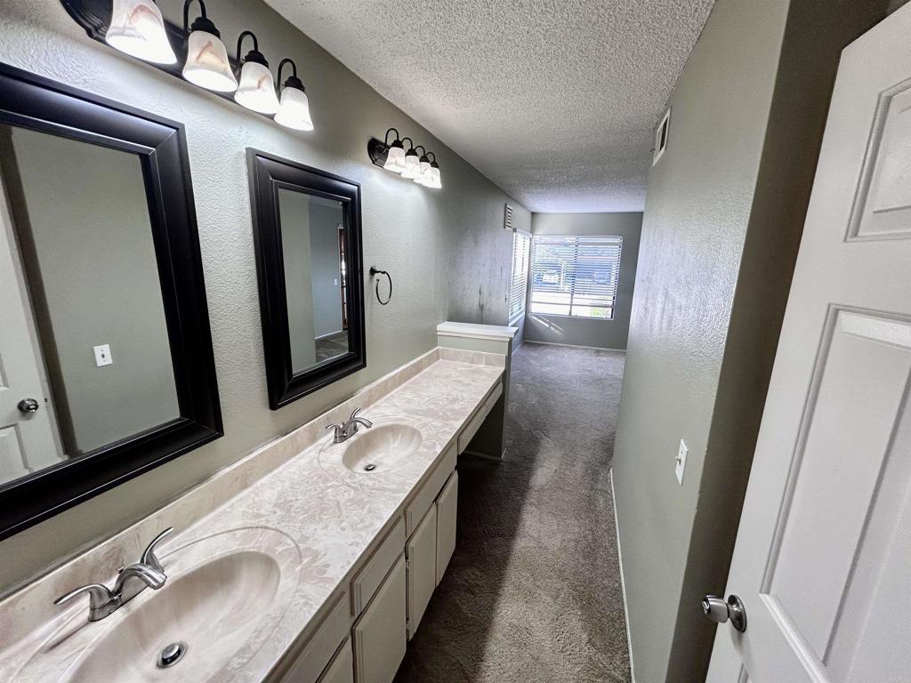 2425 Cranston Drive, Unit 204 Escondido, CA 92025 - Photo 7 of 17 a bathroom with a double vanity sink and mirror