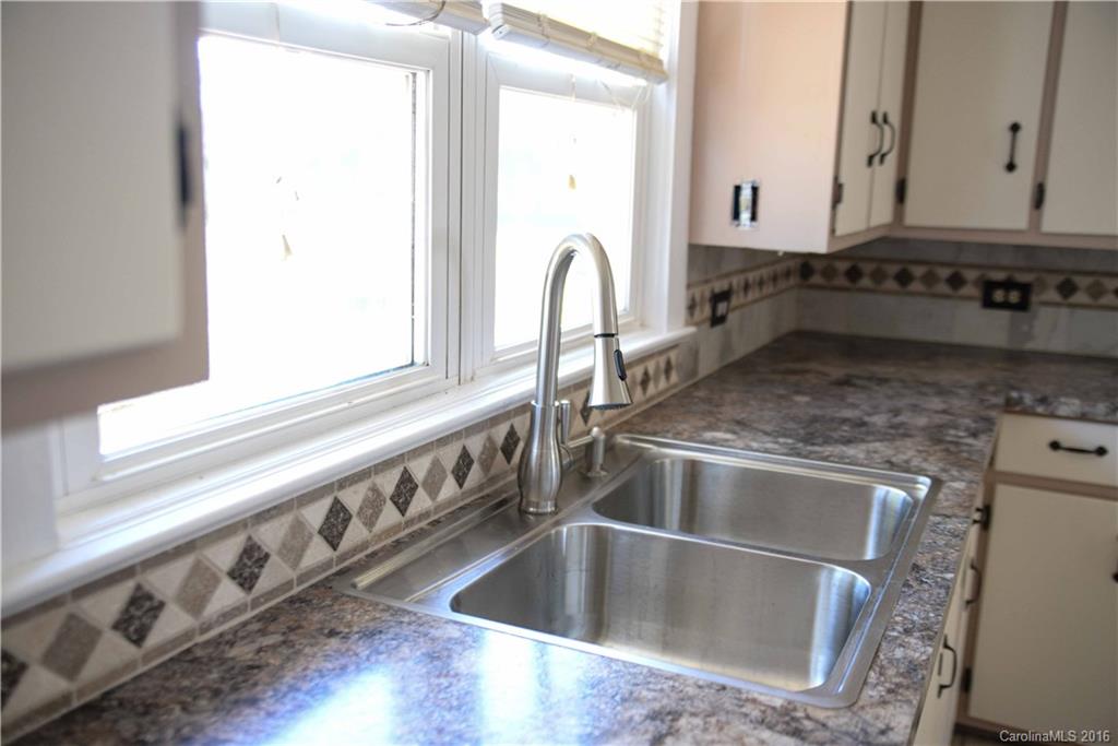 139 Duncan Road Olin, NC 28660 - Photo 13 of 24 a close view of a sink a counter space and a stove in the kitchen