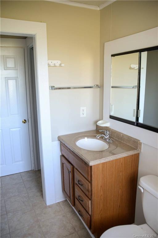 139 Duncan Road Olin, NC 28660 - Photo 23 of 24 a bathroom with a granite countertop sink and a mirror