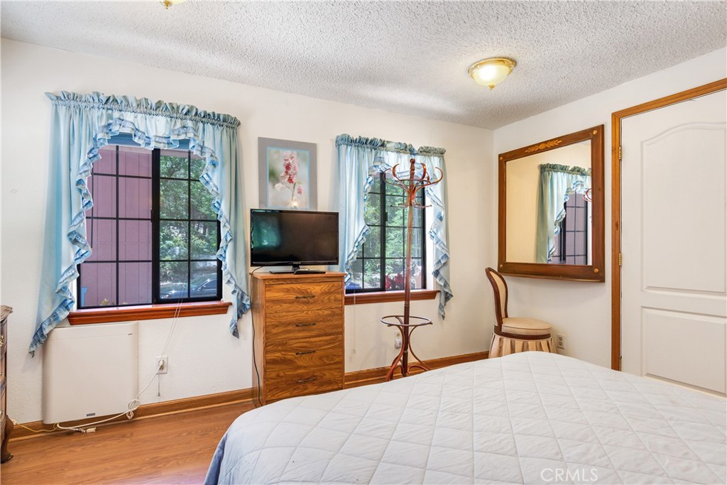 9339 Wood Road Forest Falls, CA 92339 - Photo 39 of 48 a bedroom with a bed and a flat tv screen on dresser