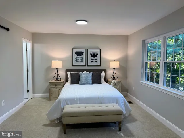 a bedroom with a bed and a large window