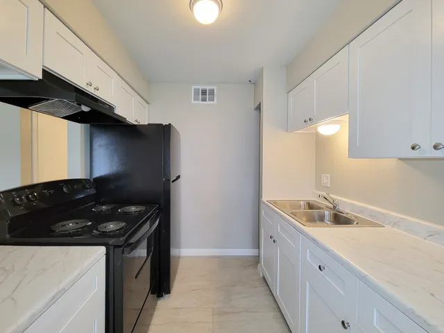 a kitchen with granite countertop a sink stainless steel appliances and cabinets