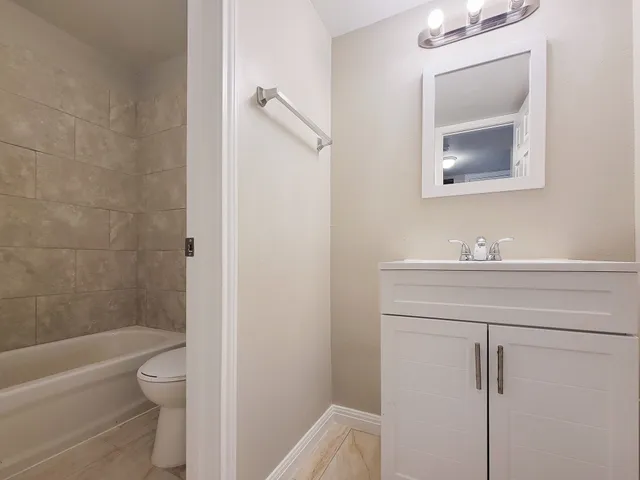 a bathroom with a granite countertop toilet a sink and bathtub