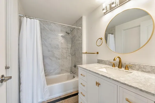 a en suite bathroom with a granite countertop double vanity sink and a mirror