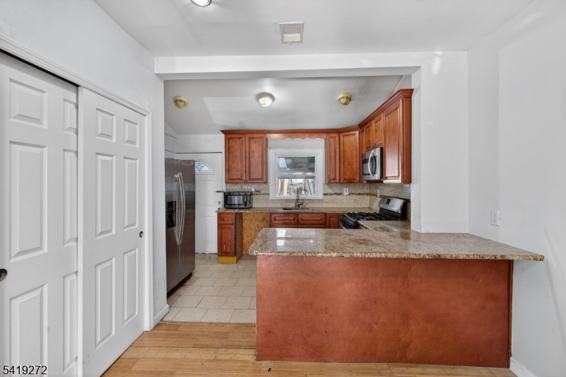 136 Smith Street Elizabeth, NJ 07201 - Photo 11 of 45 a large kitchen with stainless steel appliances granite countertop a granite counter tops and a view of living room